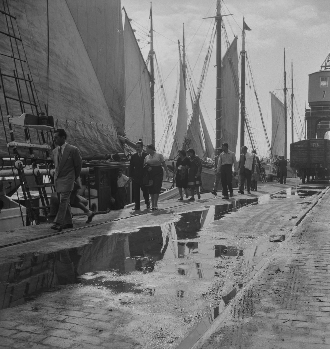 Passengers and sailing vessels at the Port of Barcelona.